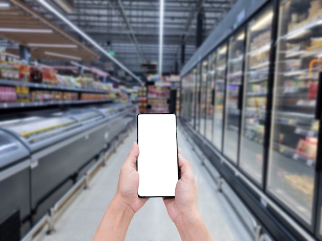 Hand hold smartphone white screen blur shopping mall background