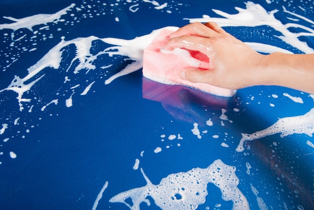 hand hold sponge over the car for washing