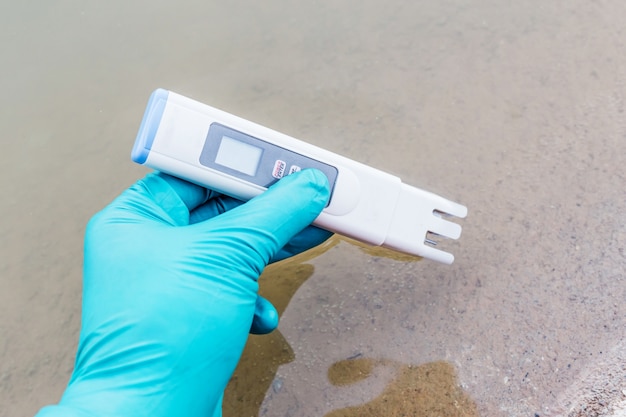 hand hold water quality tester and take sampling water for analysis 