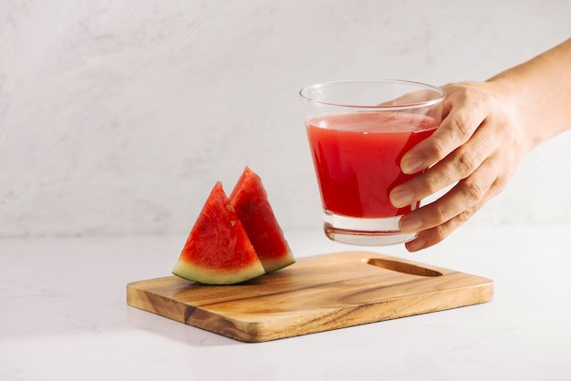 Hand hold watermelon juice with watermelon fruit