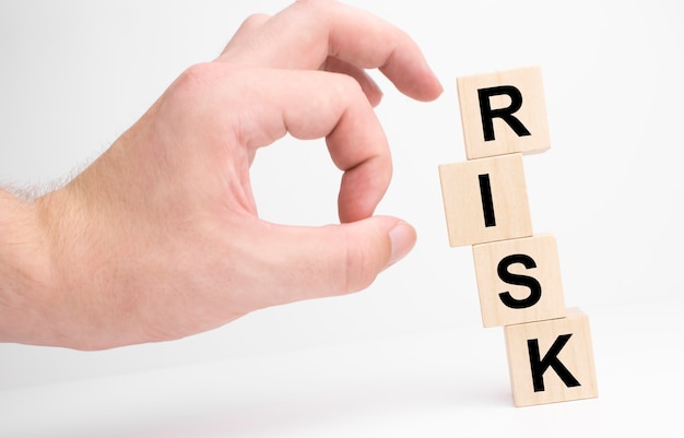 Hand hold wooden cubes with risk word. Risk management concept.White background. Copy space.