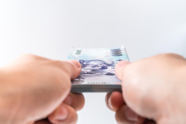 A hand holding a 1000 New Taiwan Dollar bill.