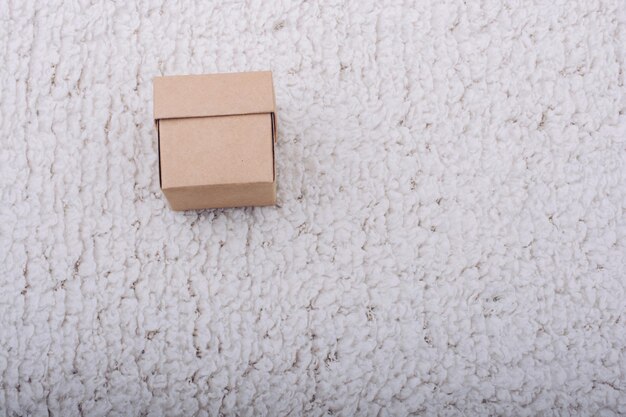 Фото Рука держит коричневую картонную коробку на белом фоне