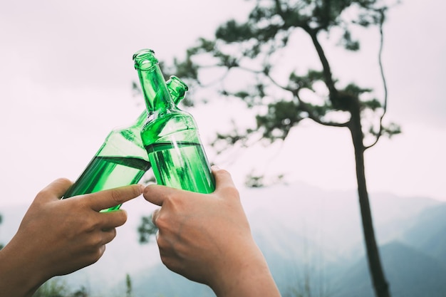 Фото Рука держит бутылку с зеленым напитком