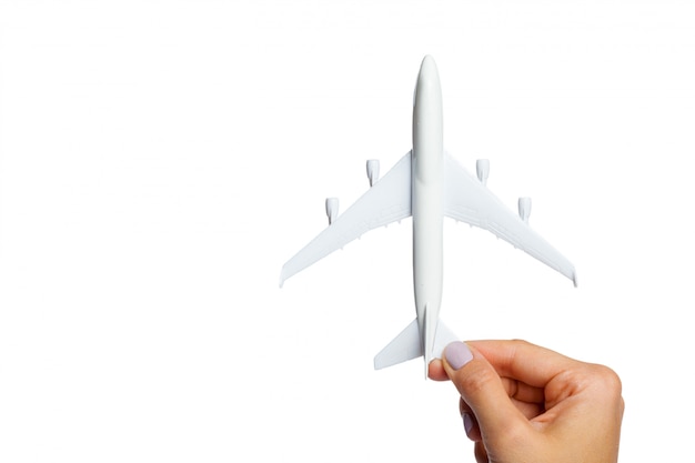 Hand holding airplane toy model isolated on white