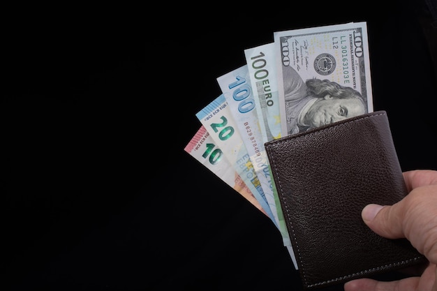 Hand holding American dollar isolated on black background