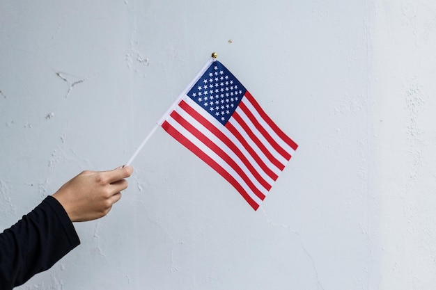 Hand holding american flag on white background