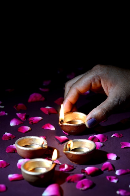 Рука держит и устраивает фонарь (дия) во время фестиваля огней Дивали