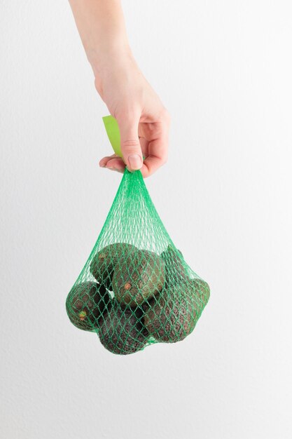 Hand holding an avocado bag