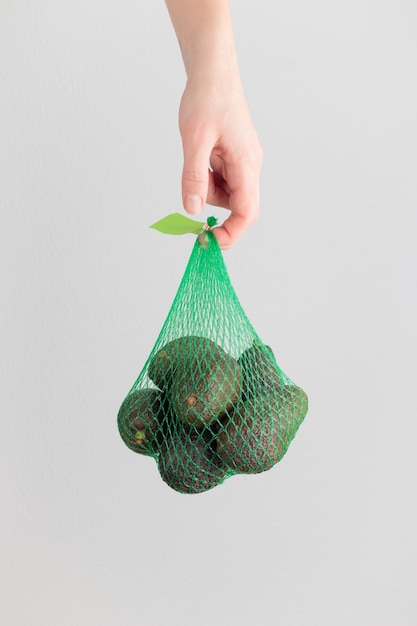 Hand holding an avocado bag