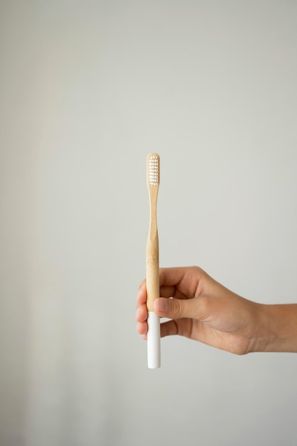 Hand holding bamboo toothbrush