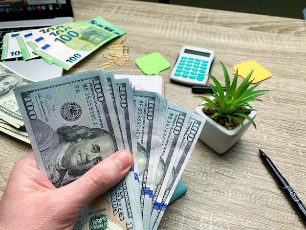 Hand holding banknote bundle of US dollar in hand