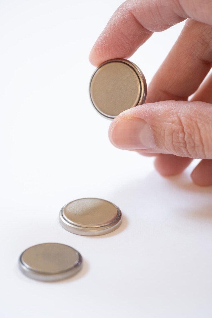 a hand holding a battery on white background