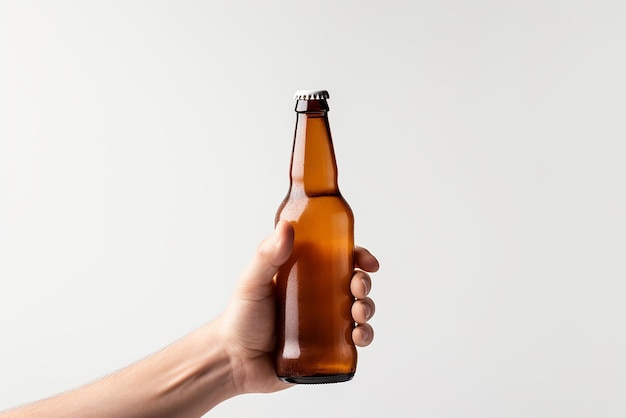 A hand holding a beer bottle on a white background