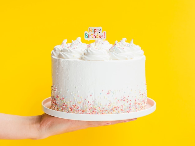 Photo hand holding big white birthday cake
