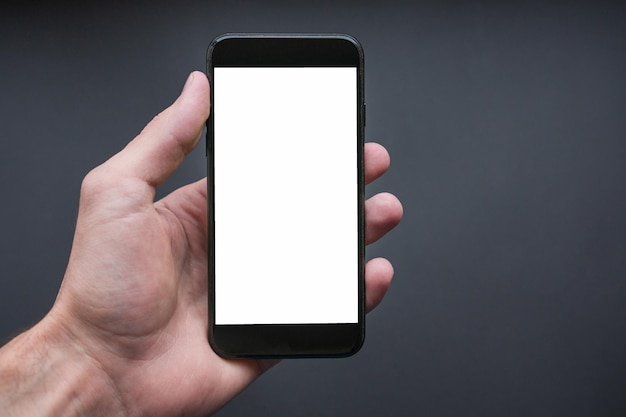 Hand holding the black smartphone with blank screen