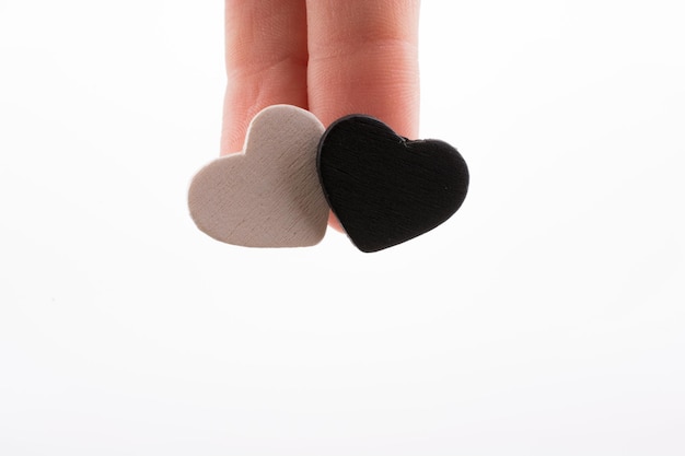 A hand holding a black and white heart with the word love on it.