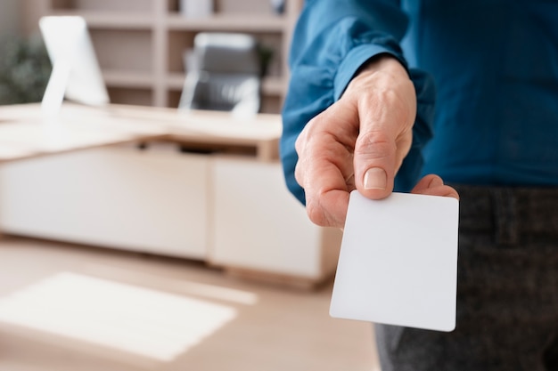 Hand holding blank business card high angle