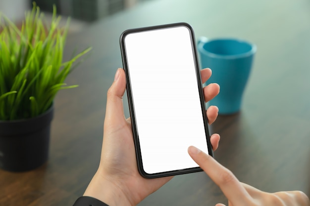 Hand holding blank screen of phone on the desk office and for graphic display montage.