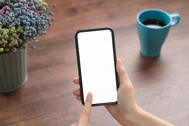 Hand holding blank screen of smartphone on the desk office and for graphic display montage.