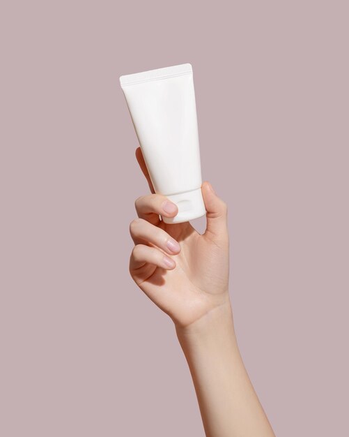 Photo hand holding blank white plastic tube on pink background cosmetic beauty product branding mockup copy space high quality photo