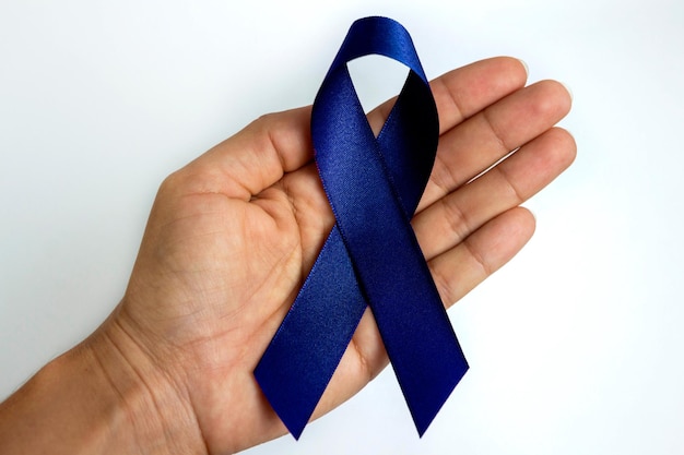 Photo hand holding a blue ribbon blue november