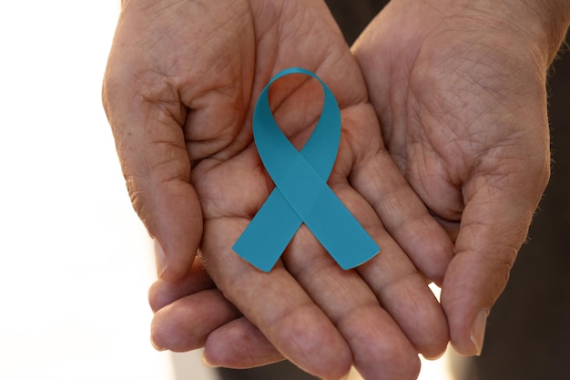 hand holding a blue ribbon blue november