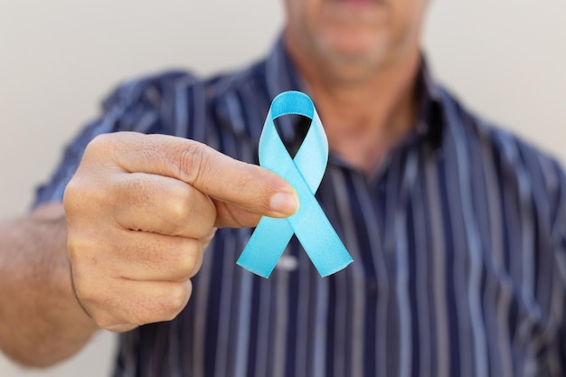 Photo hand holding a blue ribbon blue november