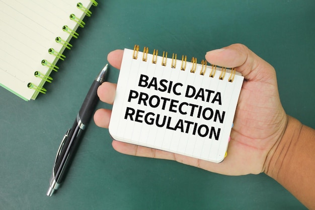 Photo hand holding a book with the words basic data protection regulation