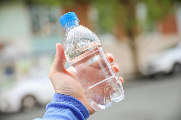 水の入ったボトルを持つ手