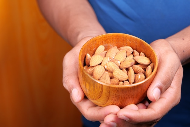 hand holding a bowl of almond close up