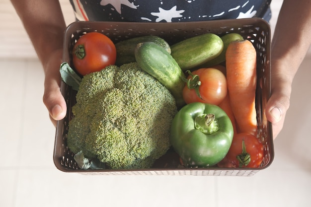 hand holding a bowl of fresh vegetables top down