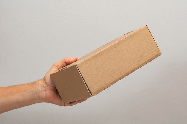 Hand holding box to pack product to be sent by mail with copy space