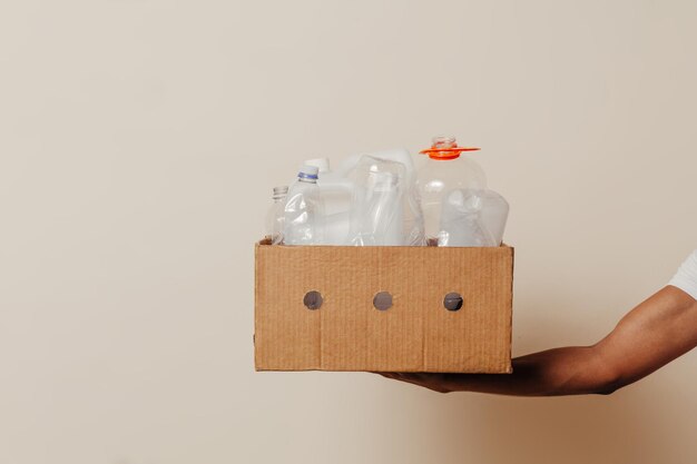 Hand holding box with trash over background