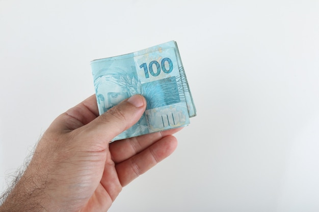 hand holding brazilian money. 100 reais banknotes. copy space.