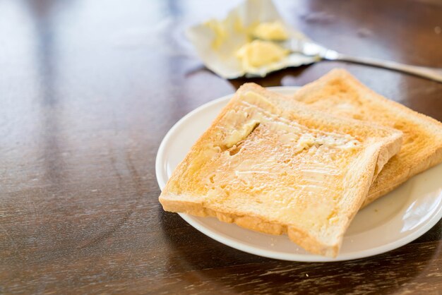 朝食とパンとバターを持っている手