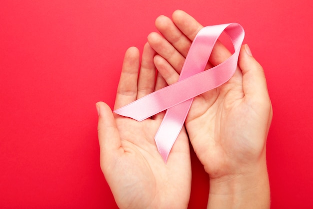 Hand holding breast cancer ribbon symbol