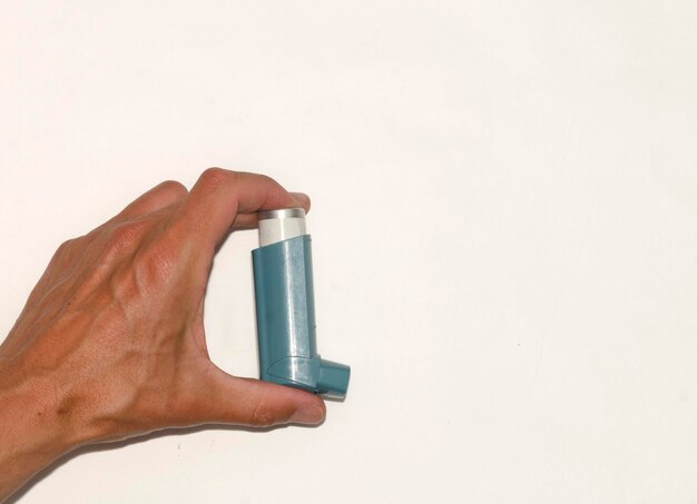 hand holding bronchial asthma spray inhaler with white background