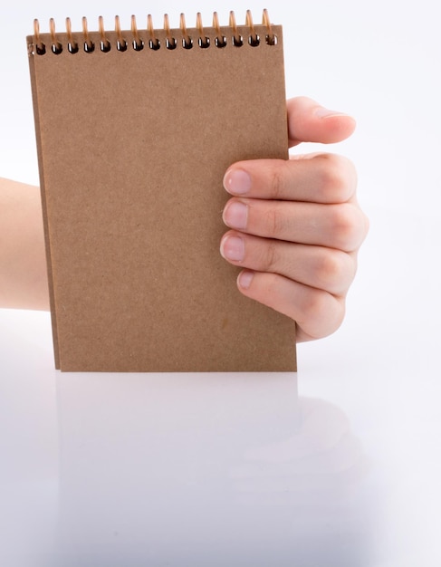 Hand holding a brown color notebook