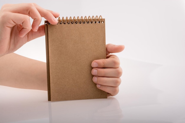 Hand holding a brown color notebook