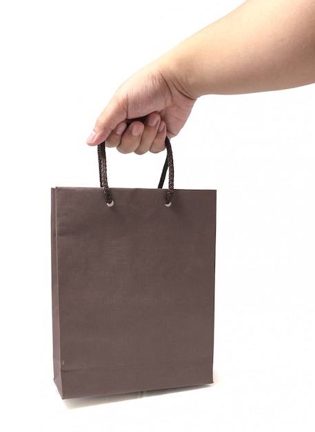 Hand holding brown shopping bags