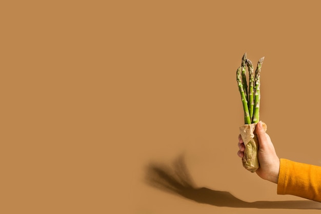 A hand holding a bunch of asparagus