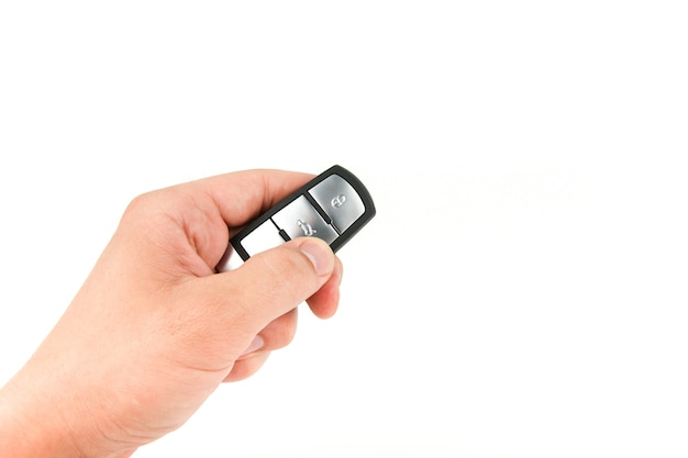 Hand holding a car key isolated on white