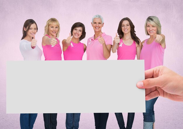 Foto mano che tiene la carta con donne rosa di consapevolezza del cancro al seno