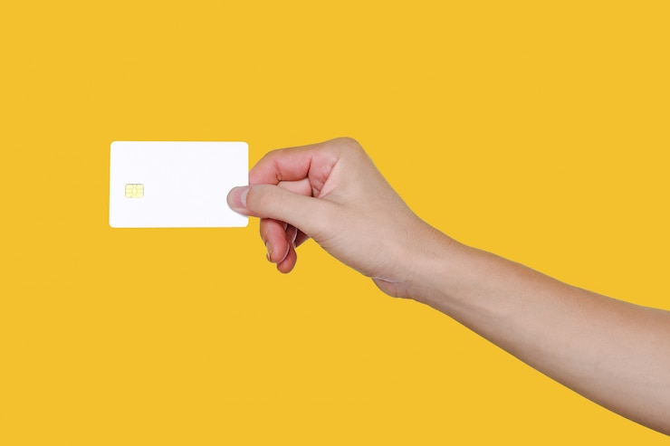 Photo a hand holding a card on the yellow background