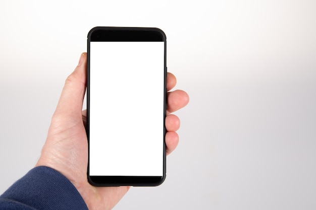 Рука держит сотовый телефон черный тонкий смартфон с пустым белым экраном для макета пустого пространства для копирования