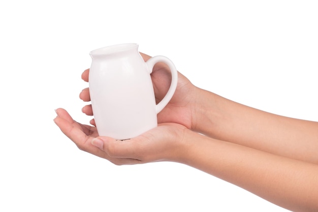 hand holding ceramic jug for milked milk isolated on white background