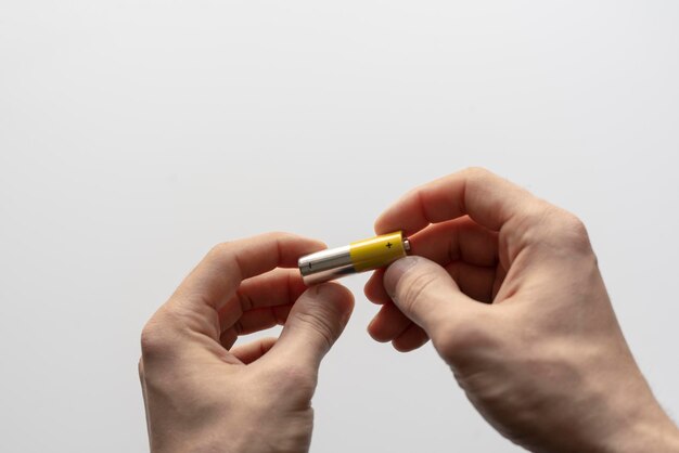 A hand holding the charged electric alkaline aa battery