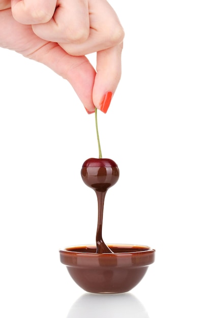 Hand holding cherry in chocolate isolated on white