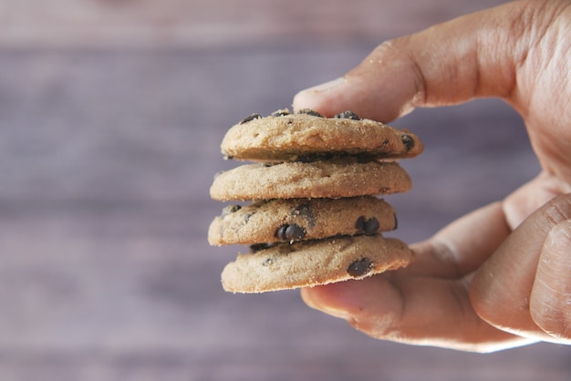 Photo hand holding chocolate chip cookies close up